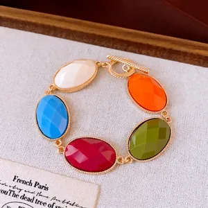 Luxurious gold-tone bracelet with vibrant multi-color oval resin stones and toggle clasp.