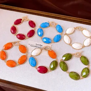 Vibrant resin oval bead bracelets with elegant gold-tone T-bar clasps set on tray