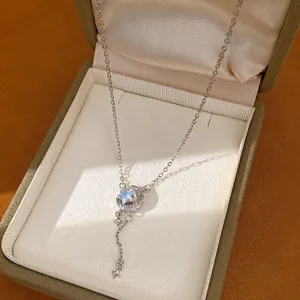Detailopname van een elegante ketting met ster- en maanhanger in een geschenkdoos
