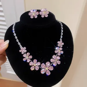 Detail view of sparkling pink zircon flower jewelry set on a black display stand