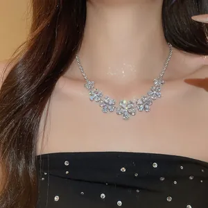 Detailed view of luxury silver flower necklace with sparkling zirconia crystals on model