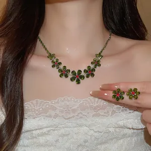 Close-up detail of luxury green crystal flower necklace and matching earrings on model.