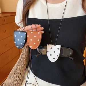 Nahaufnahme von modischen Brillen-Clips aus Leder mit Punkten in Schwarz, Braun und Weiß