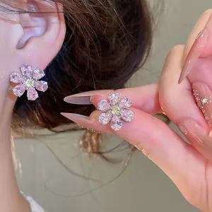 Detailed view of shimmering pink zircon flower stud earrings with yellow center
