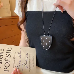 Detailansicht einer modischen Brillenhalter-Halskette aus schwarzem Leder mit Punkten.