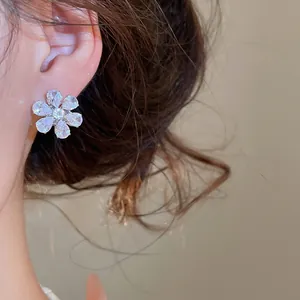 Detailed close-up of a sparkling flower-shaped stud earring with cubic zirconia stones