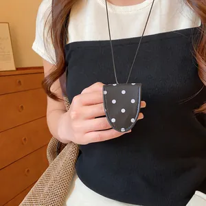 Stilvoller Leder-Brillenclip mit Punktmuster als schickes Halsketten-Accessoire.