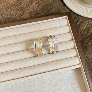 Detailaufnahme eleganter unregelmäßiger Wellenohrringe mit silberner und gelber Lackierung