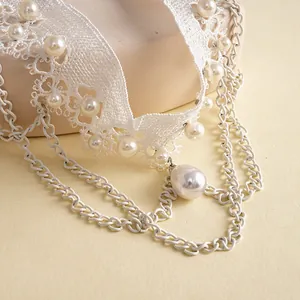 Detailansicht einer eleganten weißen Spitzen-Halskette mit Perlenakzenten und Ketten