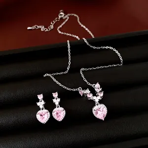 Elegante set van ketting en oorbellen met roze zirkoon hart op zwart sieradentableau