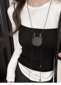 Lange Lederkordelkette mit rundem Brillenhalter-Anhänger an einem weiblichen Modell