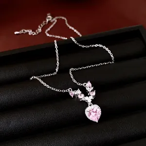 Detailopname van een elegante roze hart zirkoon ketting hanger op een sieradendoosje