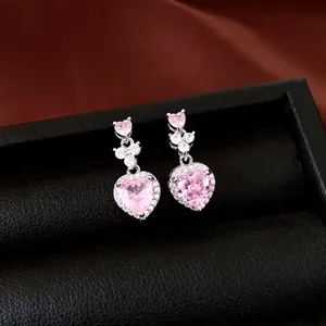 Detail van elegante roze hartvormige zirkonia oorbellen op een zwart juwelendoosje