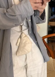 Nahaufnahme eines cremefarbenen Croissant-Beutels aus Leder mit exquisitem Metallverschluss