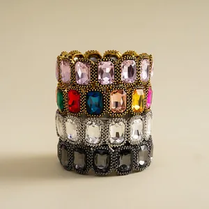 A detailed view of four stacked vintage elastic bracelets featuring vibrant geometric crystals
