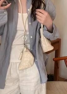 Detailansicht einer schicken, cremefarbenen Croissant-Anhänger-Halskette an einer Lederschnur.