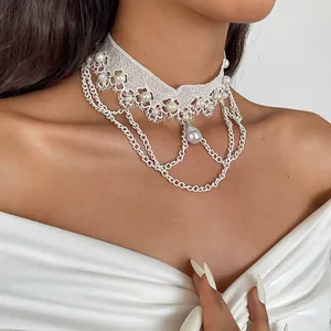 Detailaufnahme eines weißen Spitzen-Chokers mit Perlen und silbernen Kettenfransen