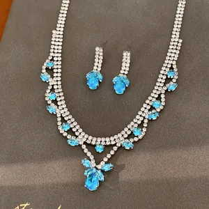 Detail van zilveren ketting en oorbellen set met hemelblauwe druppelvormige stenen.