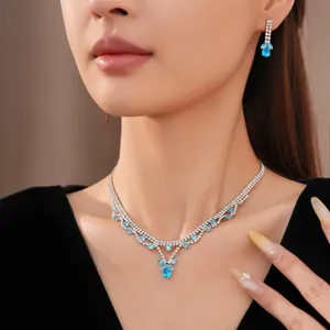 Detailopname van een luxe set met een blauwe zirkoon druppelketting en oorbellen.