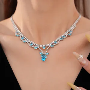 Detailweergave van elegante zilveren ketting met blauwe zirkonia druppelsteen