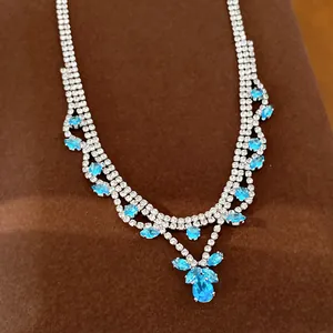 Detail van luxe zirkonia halsketting met blauwe waterdruppelhangers voor avondkleding