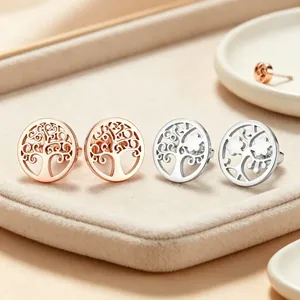 Détail des boucles d'oreilles arbre de vie évidées en acier or rose et argenté brillant