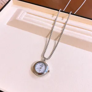Elegante collana con ciondolo a orologio argento su un vassoio espositivo di lusso