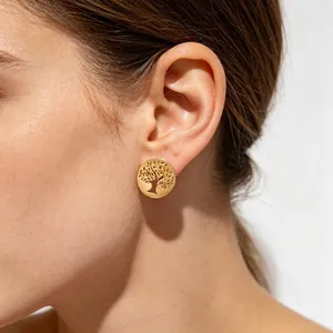Vue détaillée d'une boucle d'oreille arbre de vie en acier titane doré sur l'oreille