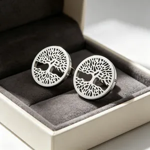 Gros plan de boucles d'oreilles Arbre de Vie en acier titane dans un écrin à bijoux gris