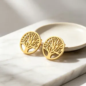 Gros plan de boucles d'oreilles en acier titane doré avec motif arbre de vie ajouré.