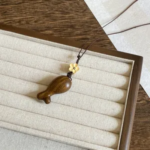 Gedetailleerd zicht op een houten eikel hanger ketting in Zen-stijl op een luxe sieradenbord.