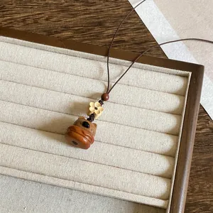 Gedetailleerd macro-aanzicht van een houten berenketting op een beige sieradenhouder