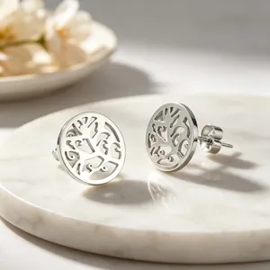 Gros plan détaillé du motif arbre de vie creux sur boucles d'oreilles en acier titane