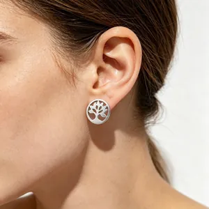 Vue détaillée d'une boucle d'oreille arbre de vie en acier titane portée sur l'oreille