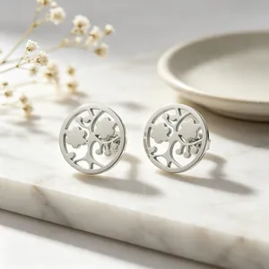 Vue détaillée du motif arbre de vie creux sur les boucles d'oreilles en acier argenté