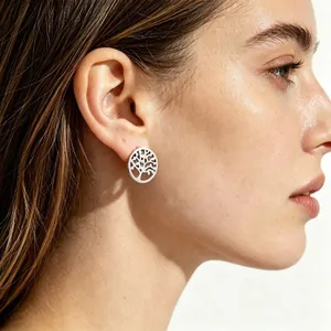 Vue détaillée d'une boucle d'oreille arbre de vie en acier titane portée à l'oreille.