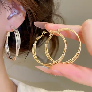 Detailed view of elegant S925 silver needle three-layer twisted gold hoop earrings