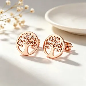 Gros plan sur les boucles d'oreilles en titane doré rose motif arbre de vie creux