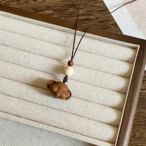 Detailweergave van een handgesneden houten dierenhanger in rustige zenstijl
