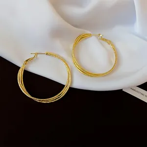 Elegant triple-layered twisted gold hoop earrings with a textured finish for women