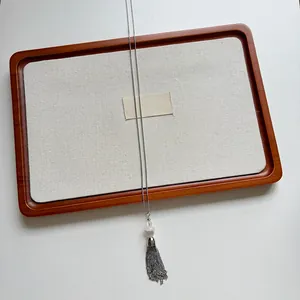 Detailed view of elegant stainless steel tassel necklace with a white shell bead