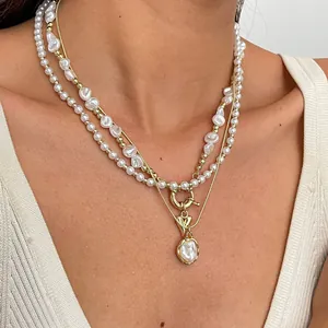 Détail de colliers en perles baroques superposés avec accents dorés sur un mannequin