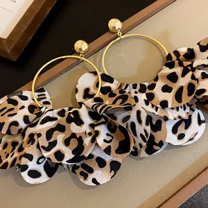 Vintage-Ohrringe mit Leopardenmuster und goldenen Reifen im warmen Maillard-Stil.
