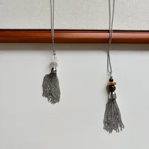 Close-up of stainless steel beaded necklaces with long metal chain tassels