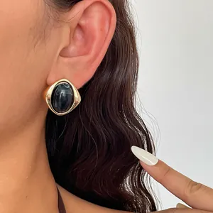 Nahaufnahme der schwarz marmorierten Acryl-Textur dieser ovalen Vintage-Ohrstecker-Modelle