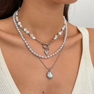Vue détaillée d'un ensemble de 3 colliers de perles rétro avec pendentif en cœur
