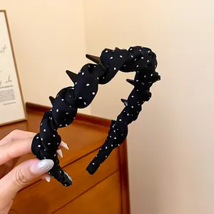 Close-up detail of black polka dot fabric headband with non-slip wave teeth design