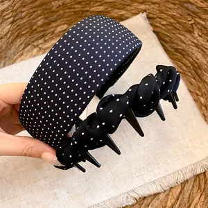 Detailed macro view of black and white polka dot fabric headbands with anti-slip grip teeth