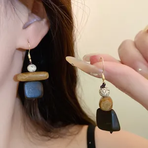 Detailansicht von Vintage-Holzohrringen mit gesprenkelten Perlen und goldenen Haken