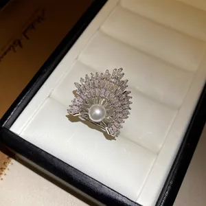 Detailansicht eines silberfarbenen Sonnenstrahl-Rings mit Perle und klaren Kristallen